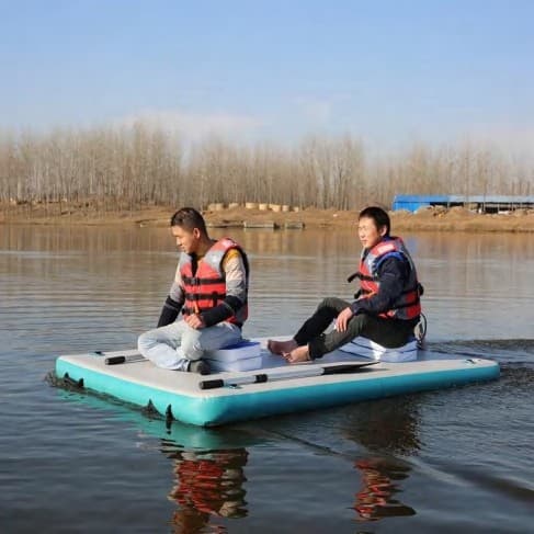 Two people in life jackets relaxing on an inflatable on a calm lake